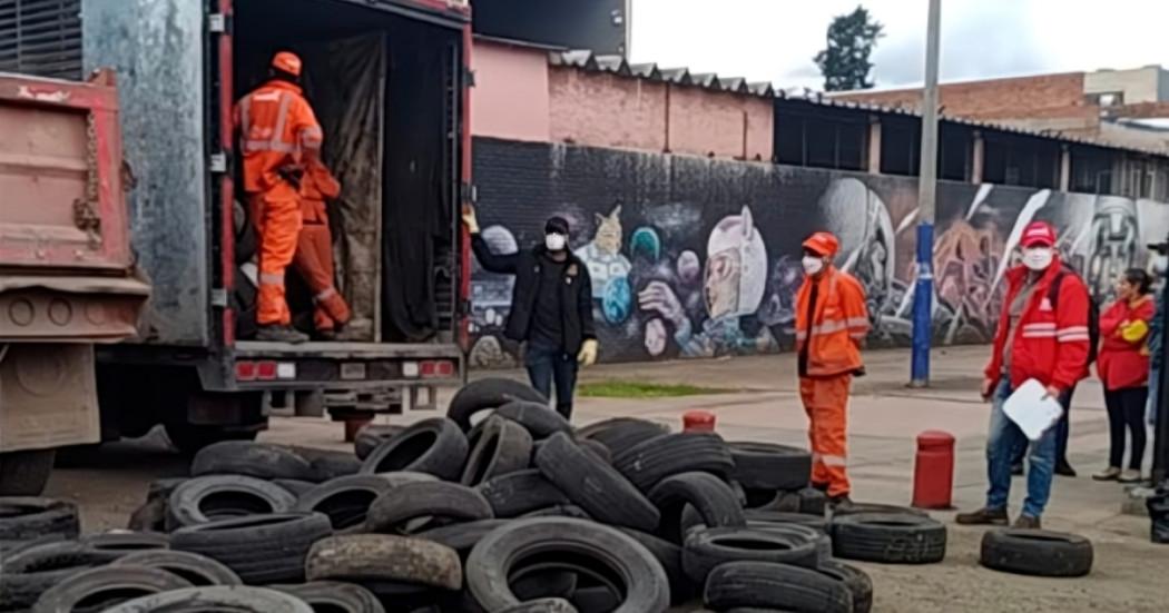 Foto que muestra llantas y personas limpiando 