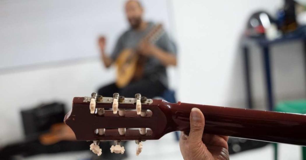 Foto que muestra una persona sosteniendo una guitarra