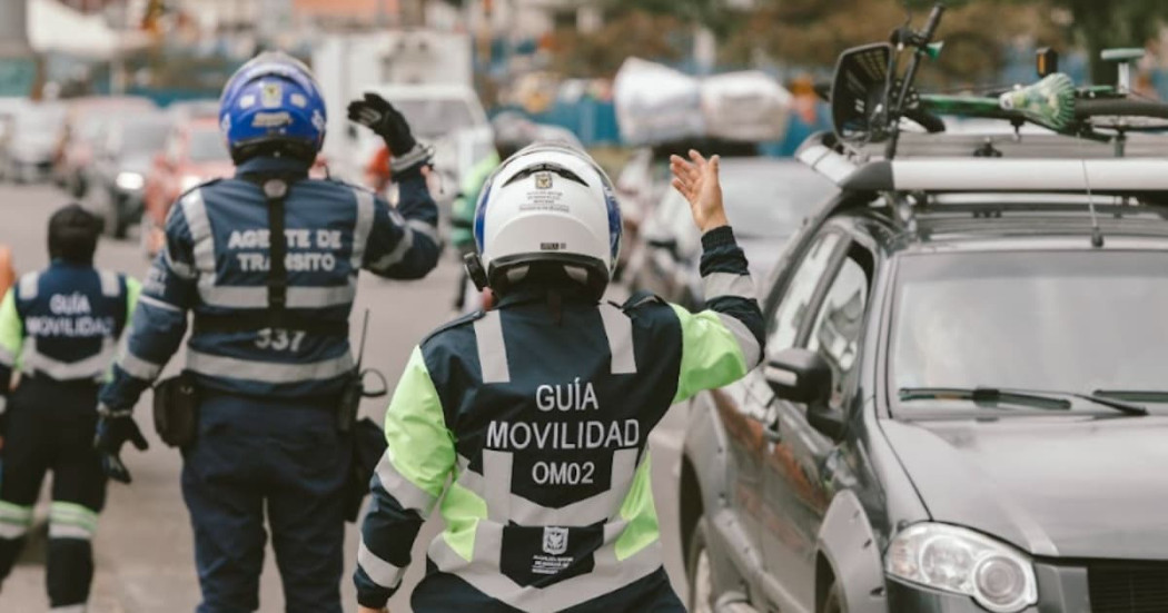 Foto de tres agentes de tránsito al lado de un carro