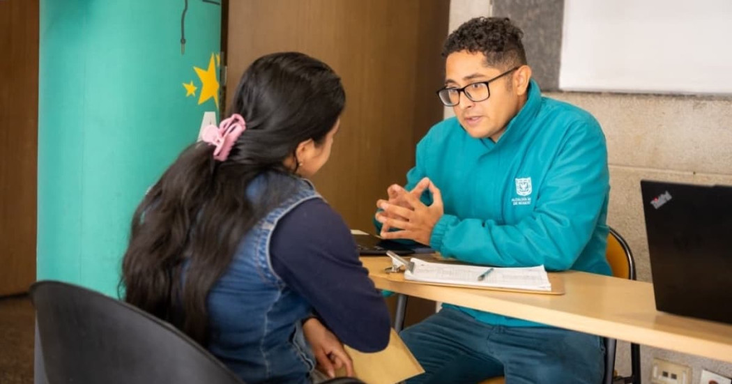 Foto de un funcionario de la Secretaría del Hábitat en Bogotá asesorando a una mujer.