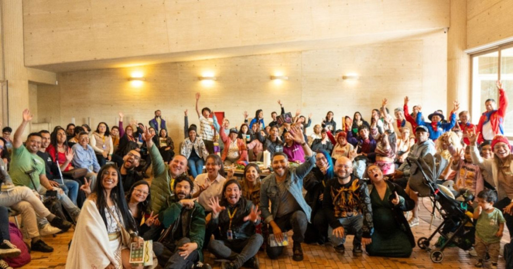 Imagen de grupo de personas con mano levantada de celebración en instalaciones de BibloRed