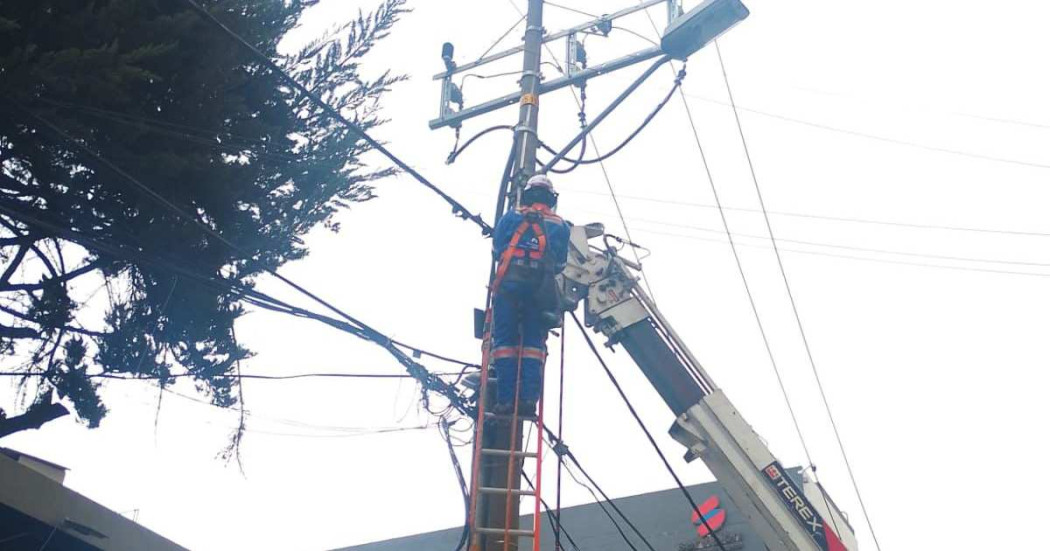 Foto que muestra una persona con uniforme de Enel Colombia trabajando en un poste de energía
