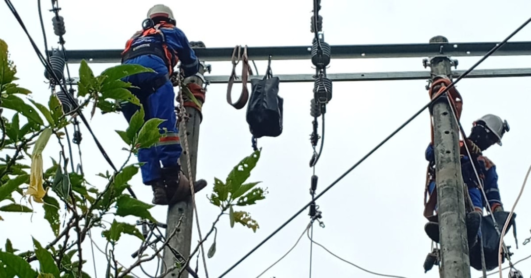 Foto que muestra dos personas con uniforme de Enel Colombia en un poste de luz