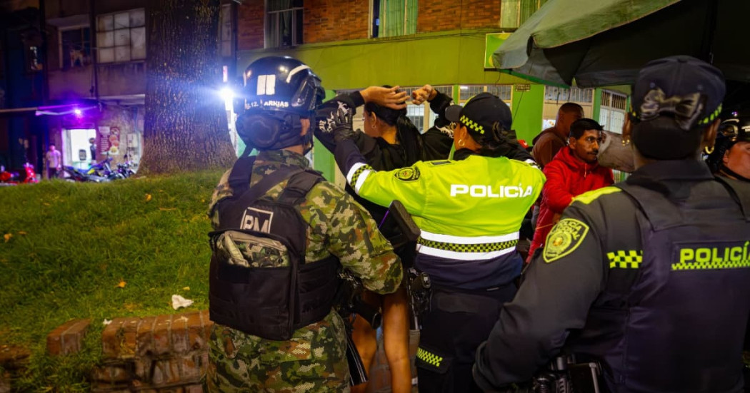 Uniformadas de la Policía y el Ejército registrando a personas.