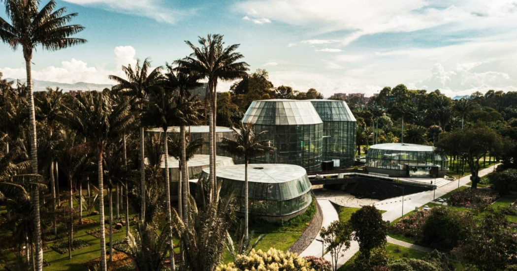 Vista aérea del Tropicario Jardín Botánico de Bogotá con invernaderos rodeados de palmeras tropicales
