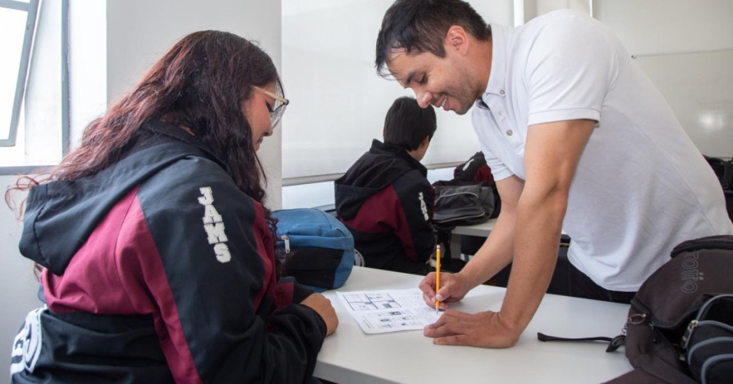 Foto que muestra dos personas hablando y escribiendo en un papel 