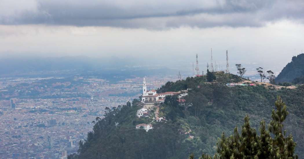 Foto pánoramica de Bogotá que muestra la iglesia de Monserrate, árboles y edificios 