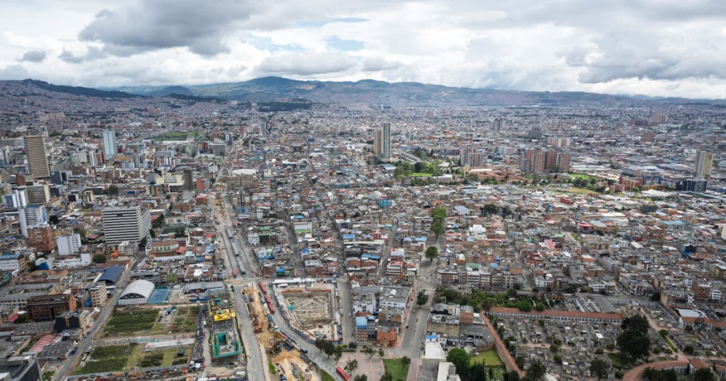 Vista aérea de Bogotá con edificaciones densas, vías principales y cielo nublado