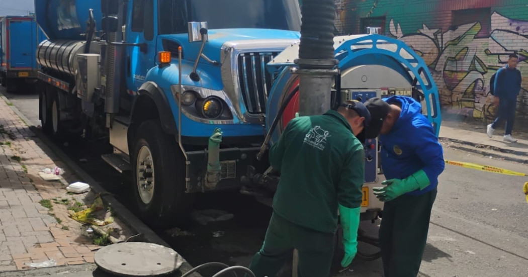Foto que muestra personas con el uniforme del Acueducto de Bogotá trabajando en una alcantarilla