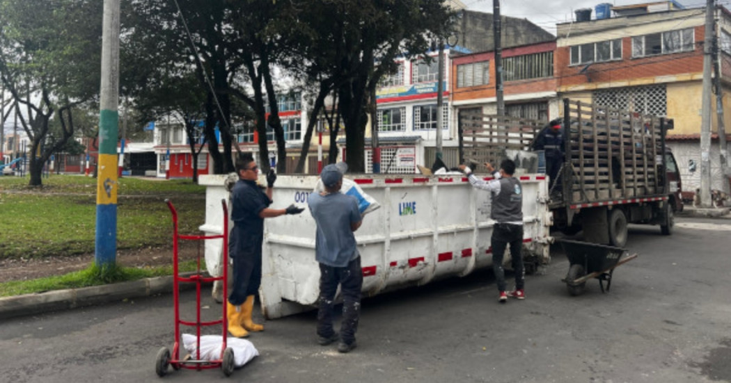 Foto que muestra personas colocando residuos en un ecopunto 