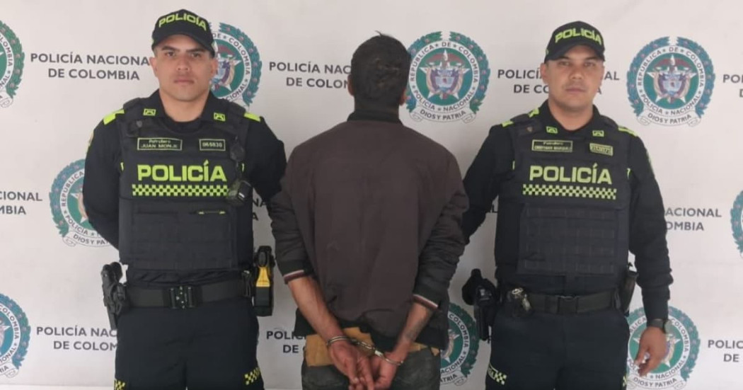 Dos policías con una persona capturada