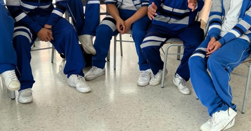 Estudiantes de colegio sentados en sillas.