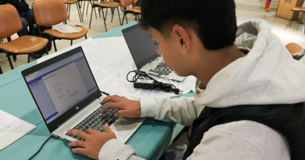 Foto que muestra a un hombre escribiendo en un computador