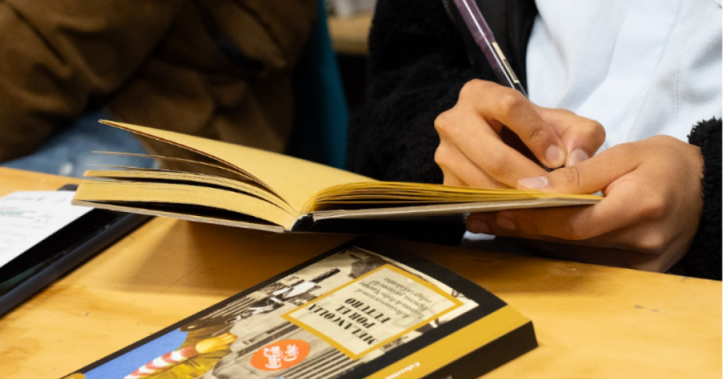 Imagen de una persona escribiendo a mano en un cuaderno.