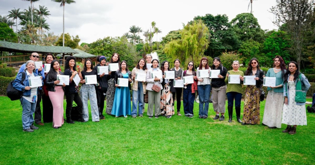 Grupo de participantes sostiene certificados tras formación en Jardín Botánico de Bogotá