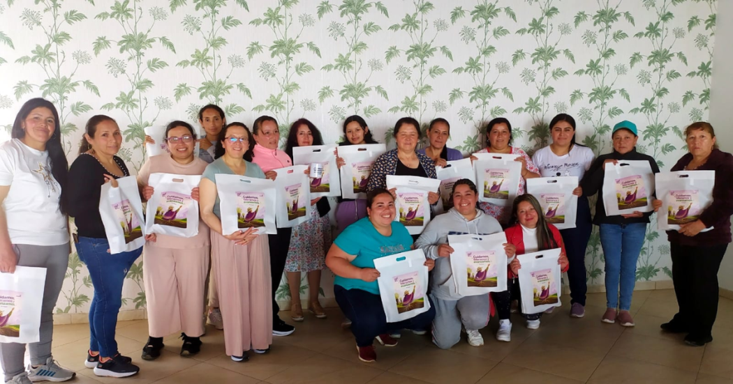 Foto de un grupo de mujeres posando con una bolsa blanca 