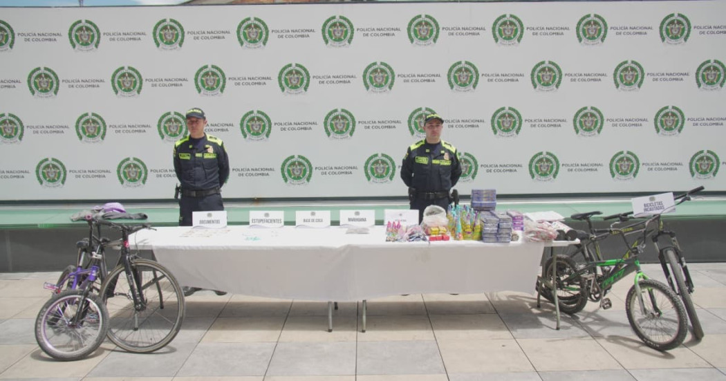 Uniformados de la Policía junto a mercancía incautada y bicicletas recuperadas.