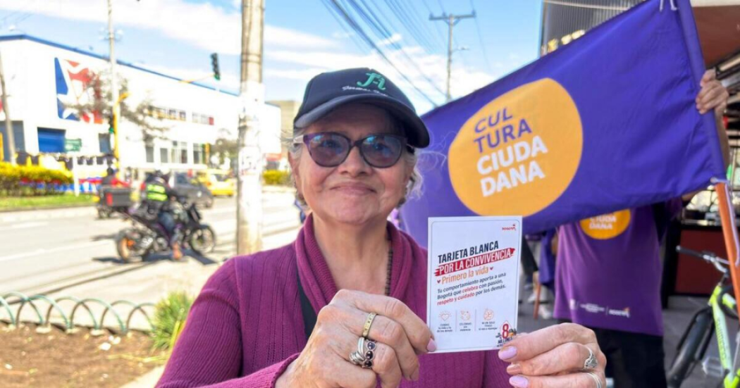 Iamgen de una mujer mostrando algunas de las piezas de comunicación de la campaña.