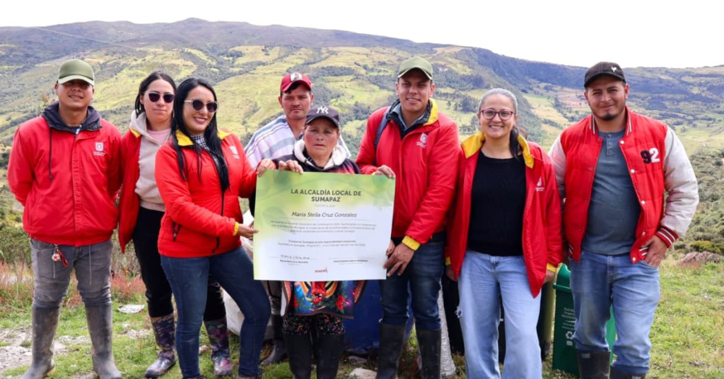 Funcionarios de la Alcaldía Local de Sumapaz con la comunidad mostrando un diploma de una firma simbólica de un acuerdo