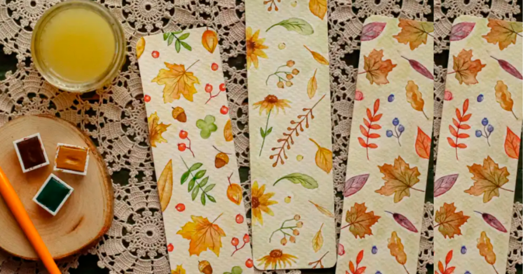 Imagen de una mesa en la que hay unas pinturas, un picnel y tres servilletas con dibujos de flores.