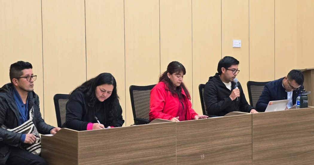 Foto de cuatro personas en un auditorio