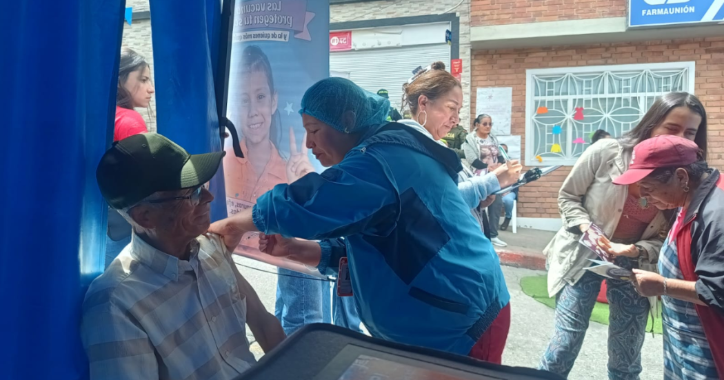 Foto de una enfermera colocando una vacuna en el hombro de una persona