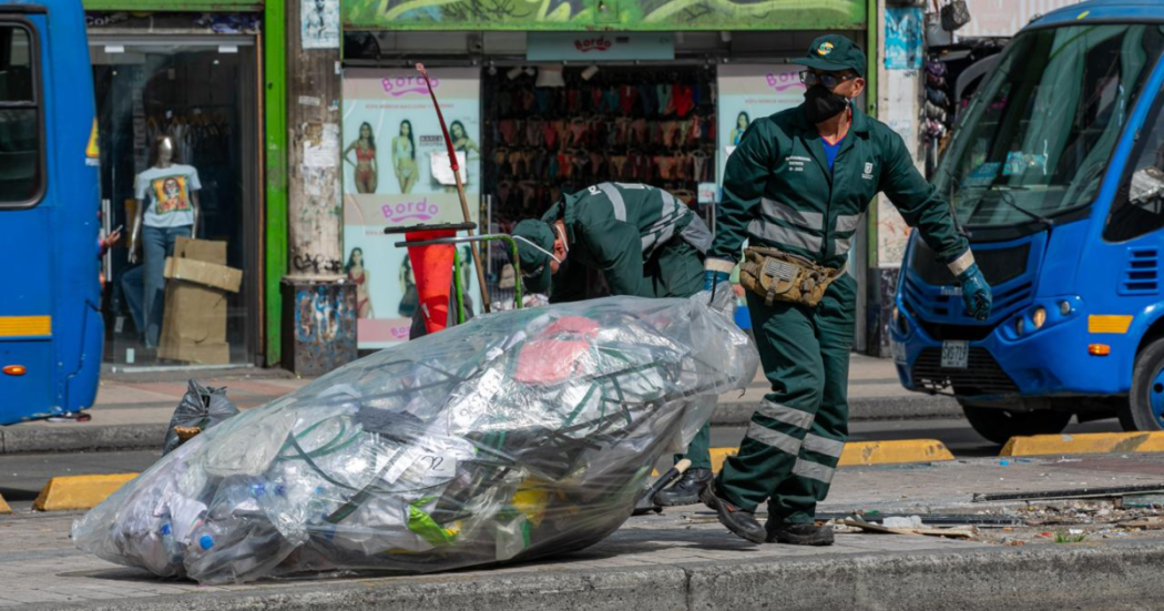 Imagen de Jorge cargando una bolsa de basura en una calle