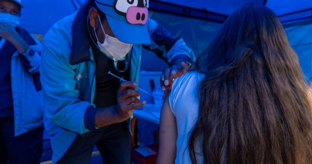 Foto de una enfermera colocando una vacuna en el hombro de una persona