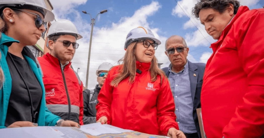 Foto que muestra un grupo de personas hablando con chaquetas rojas y casco blanco