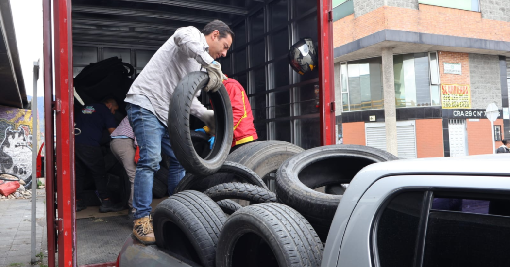 Imagen de una persona cargando llantas