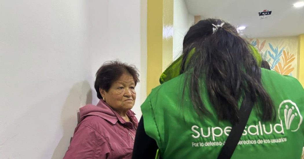 Mujer siendo atendida por una funcionaria de la Superintendencia de Salud.