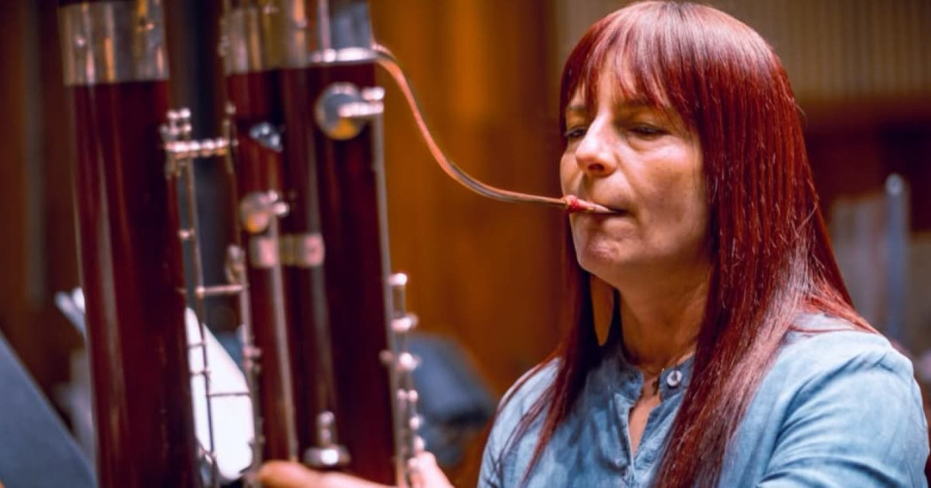 Mujer tocando un instrumento de viento.