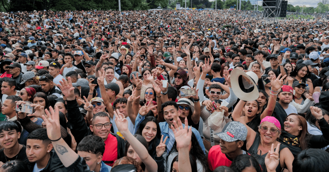 Multitud asiste a concierto masivo al aire libre en Bogotá con miles de asistentes reunidos frente al escenario principal.