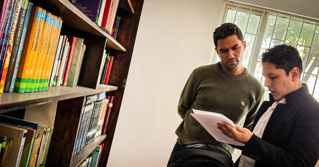 Foto de hombres viendo un libro