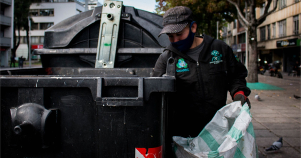 Foto que muestra una persona sacando residuos de un contenedor de basura