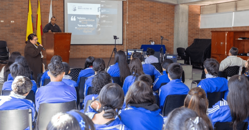 Foto que muestra estudiantes sentados en un salón de clases