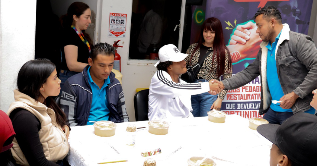 Imagen de varias personas hablando mientras comen