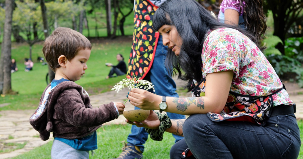 Imagen de la artista formadora con un niño en un parque.