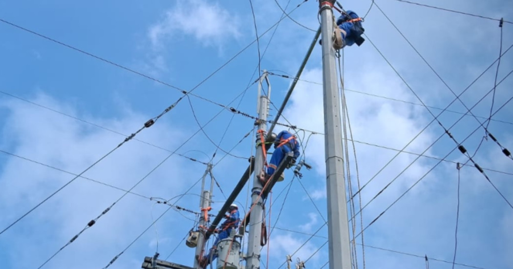 Foto que muestra dos personas con el uniforme de Enel Colombia trabajando en una antena de energía