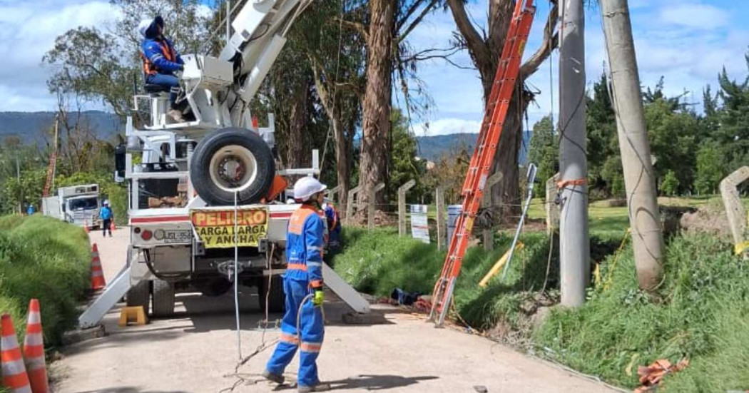 Foto que muestra dos personas con el uniforme de Enel Colombia realizando labores de mantenimiento