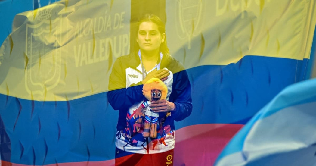 Paradeportista del Equipo Bogotá participa en ceremonia de premiación de los Juegos Parasuramericanos Valledupar 2026, con la bandera de Colombia superpuesta durante la interpretación del himno nacional.
