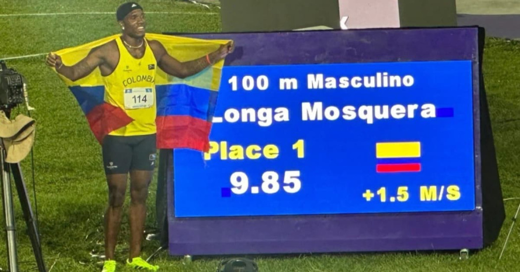 Ronal Longa celebra victoria 100 metros con bandera y marcador electrónico iluminado
