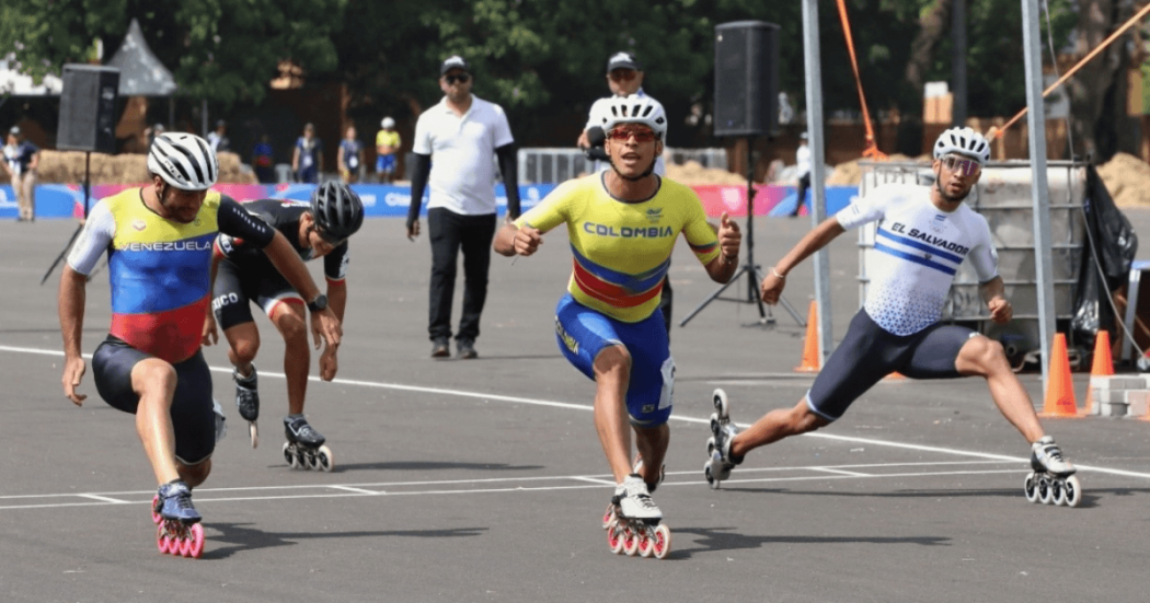 Patinadores de velocidad de Colombia, Venezuela, México y El Salvador compiten en la llegada de una prueba sobre pista asfaltada durante los Juegos Centroamericanos y del Caribe Santo Domingo 2026.
