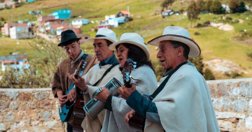 Imagen de cuatro artistas con guitarras, ruanas y sombreros