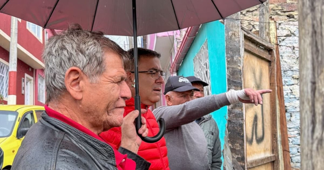 Personas participan en recorrido comunitario con el IDIGER bajo la lluvia durante jornada de diálogo sobre gestión del riesgo en Bogotá.