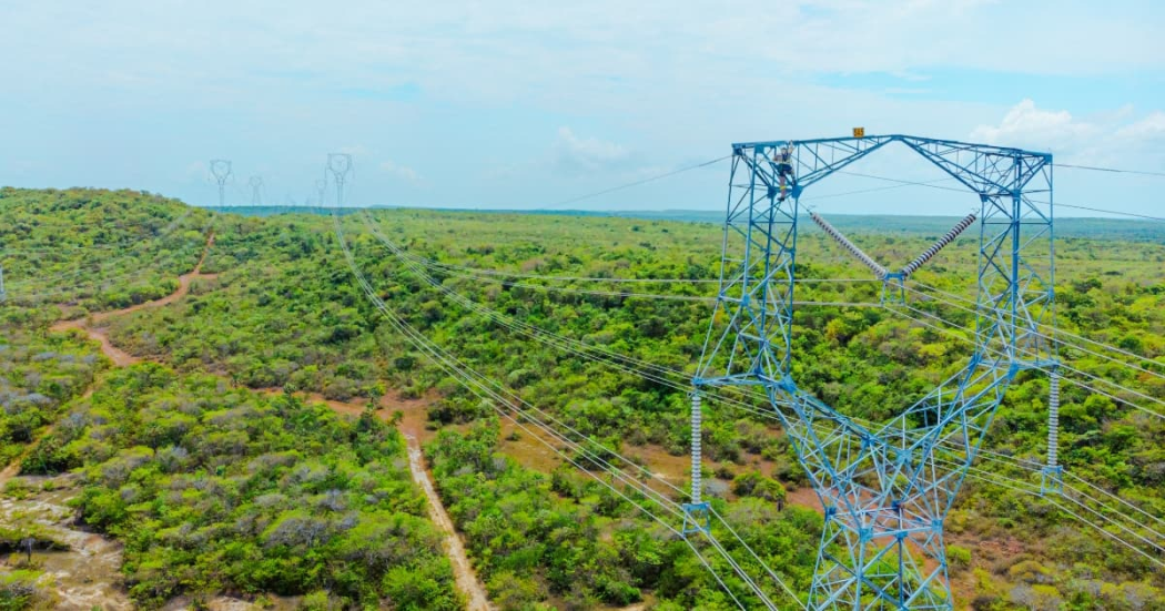 Foto que muestra una antena de energía y árboles 