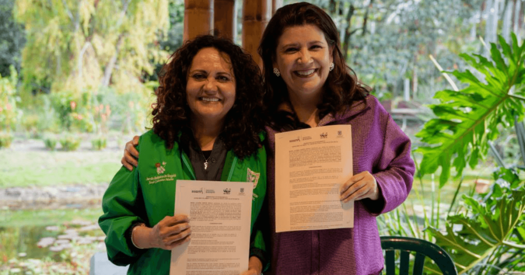 María Claudia García Dávila, directora del Jardín Botánico de Bogotá y Sandra Valenzuela, directora de WWF Colombia, sostienen documentos de cooperación durante la firma de una alianza estratégica para impulsar acciones conjuntas de conservación ambiental y biodiversidad.