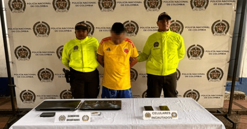 Hombre capturado en medio de dos policías, junto a elementos incautados.