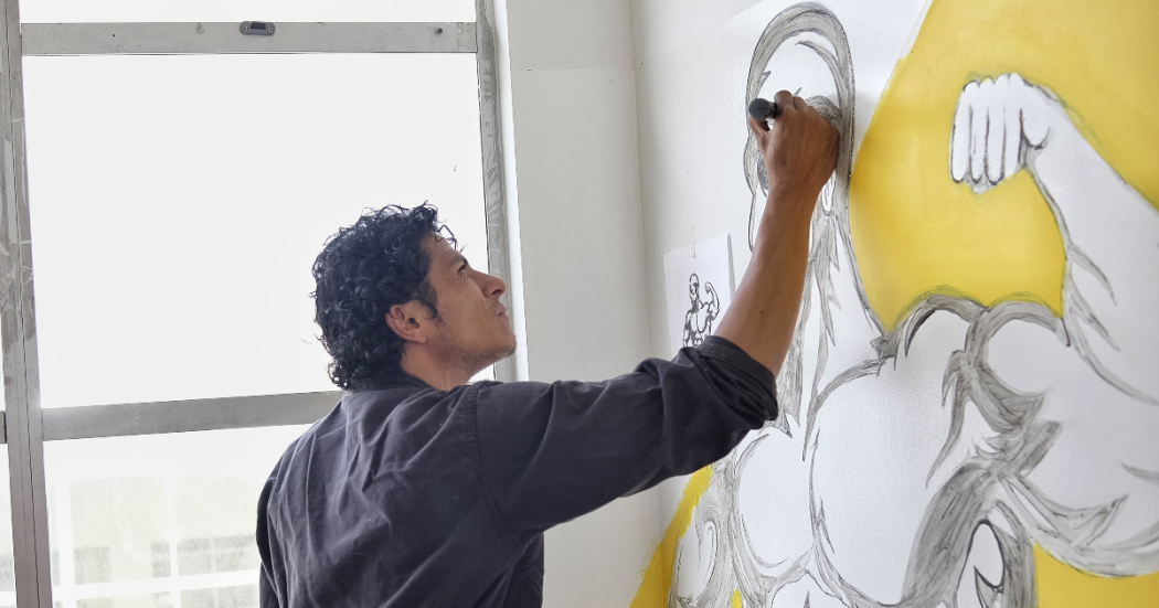 Imagen de un hombre pintando en una pared