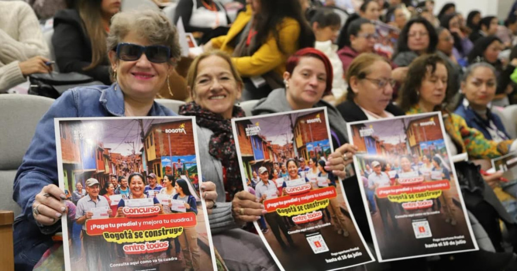Mujeres emprendedoras mostrando un afiche de la Secretaría de Hacienda